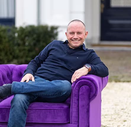 Mike Raafs op een paarse bank voor het pand van Morgen Legal.